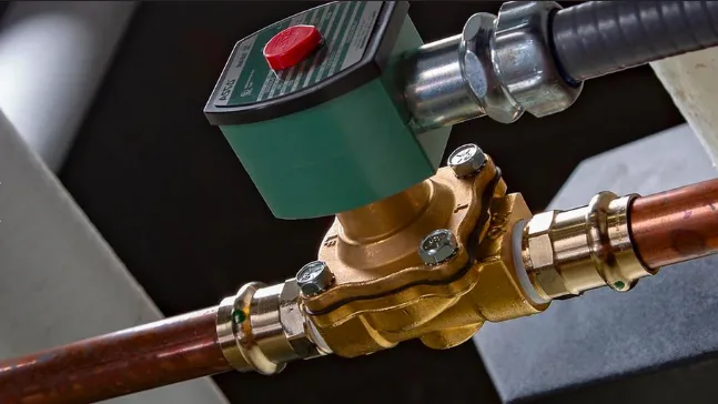 Correct vertical mounting orientation of an ASCO SCG353A047 solenoid coil on a dust collector manifold.